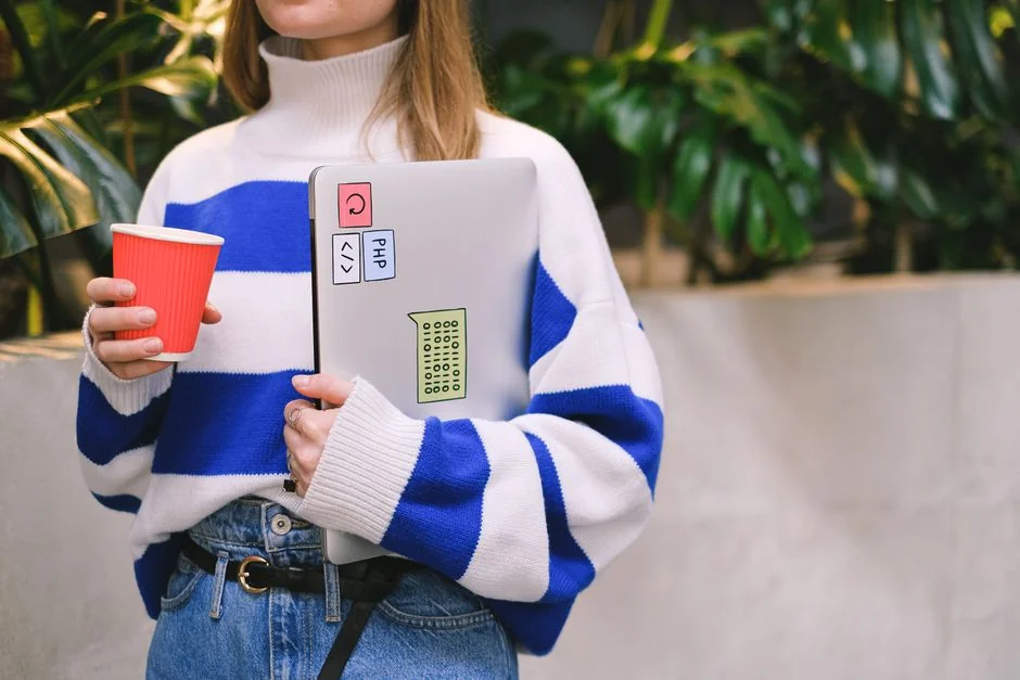 Build your dream website for your future. A laptop, MacBook, on top of a portable table with coffee tea mug on the side.
